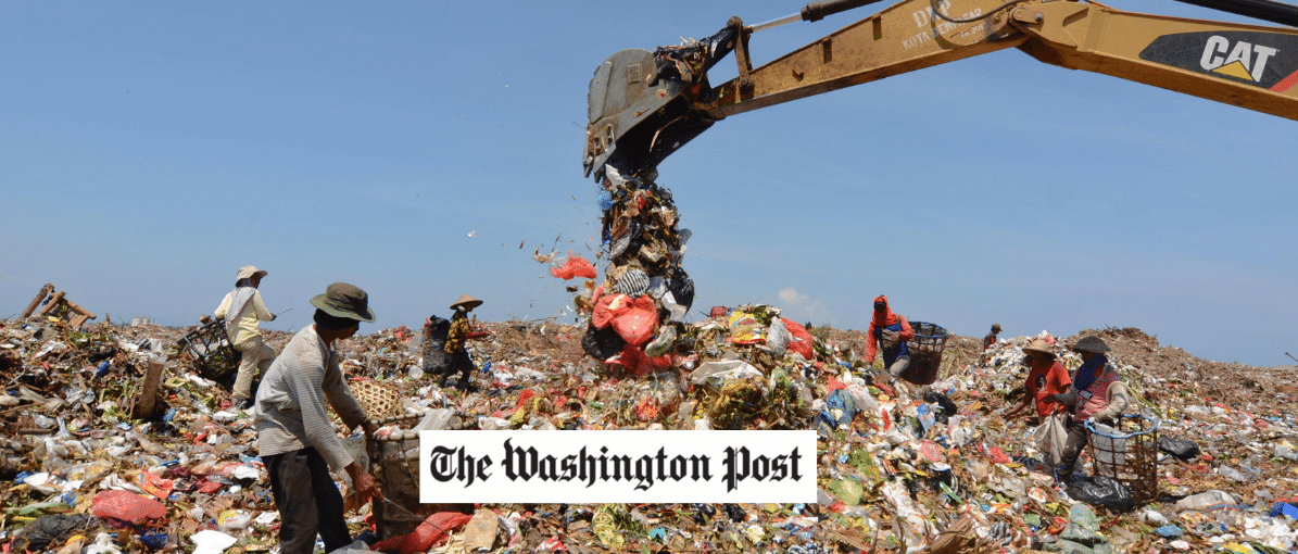 a crane in a large trash pile, Washington Post logo in foreground