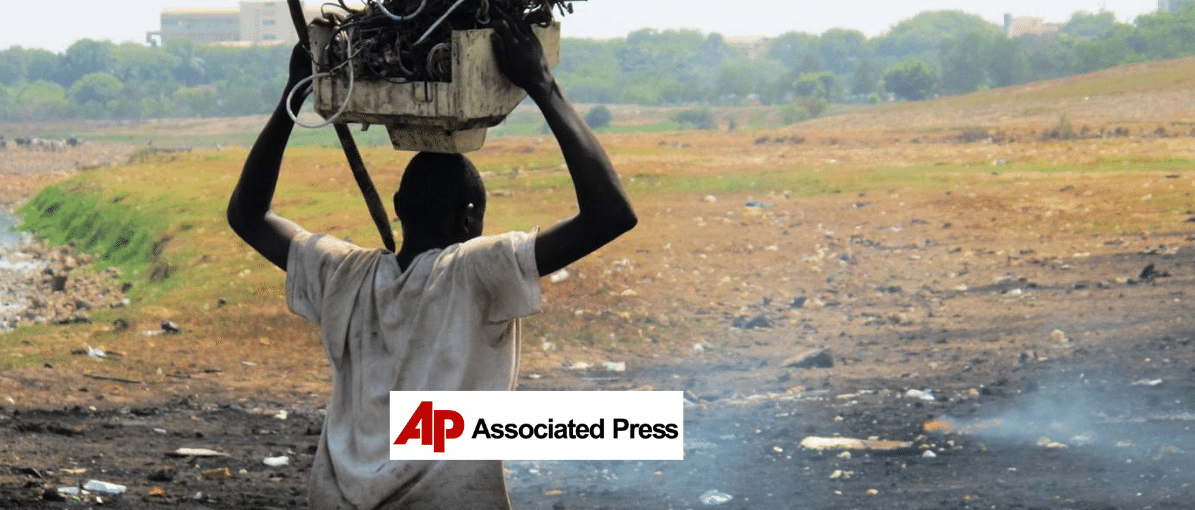 a man carrying trash over his head, AP logo in the foreground