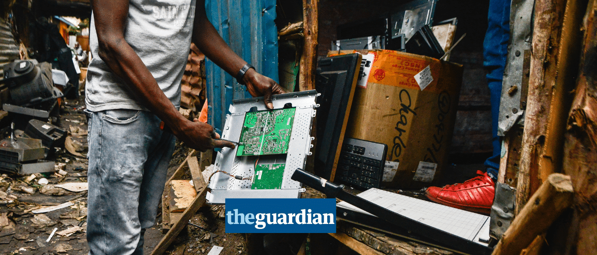 a waste picker holding a piece of plastic e-waste, Guardian logo in the foreground