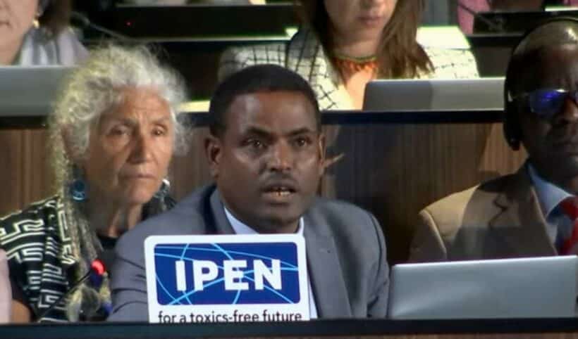 Tadesse Amera speaking at a plenary session with IPEN members by his side