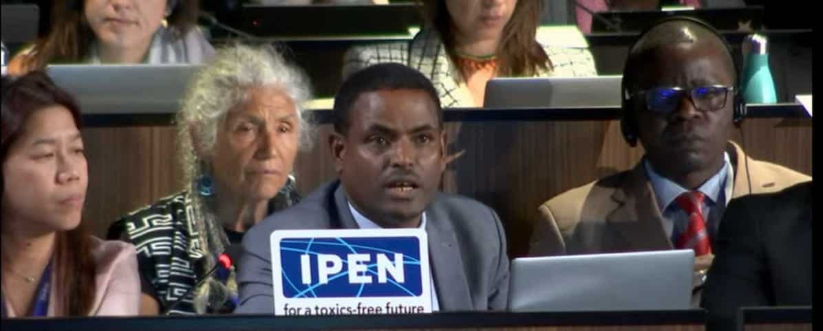 Tadesse Amera speaking at a plenary session with IPEN members by his side