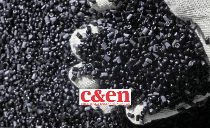 a white glove with a large handful of black plastic pellets, C&EN logo in the foreground