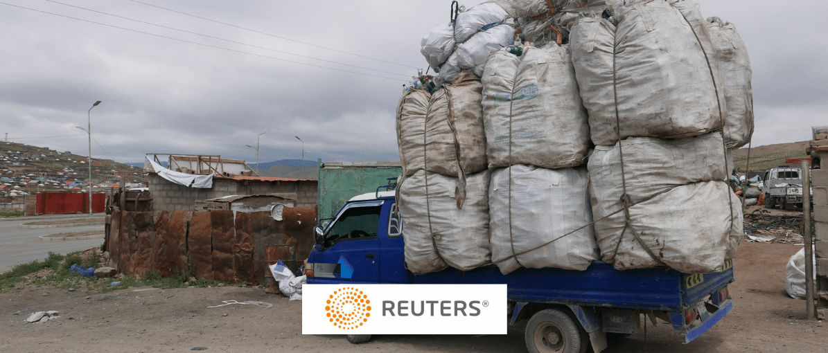 a truck piled high with trash, Reuters logo in foreground