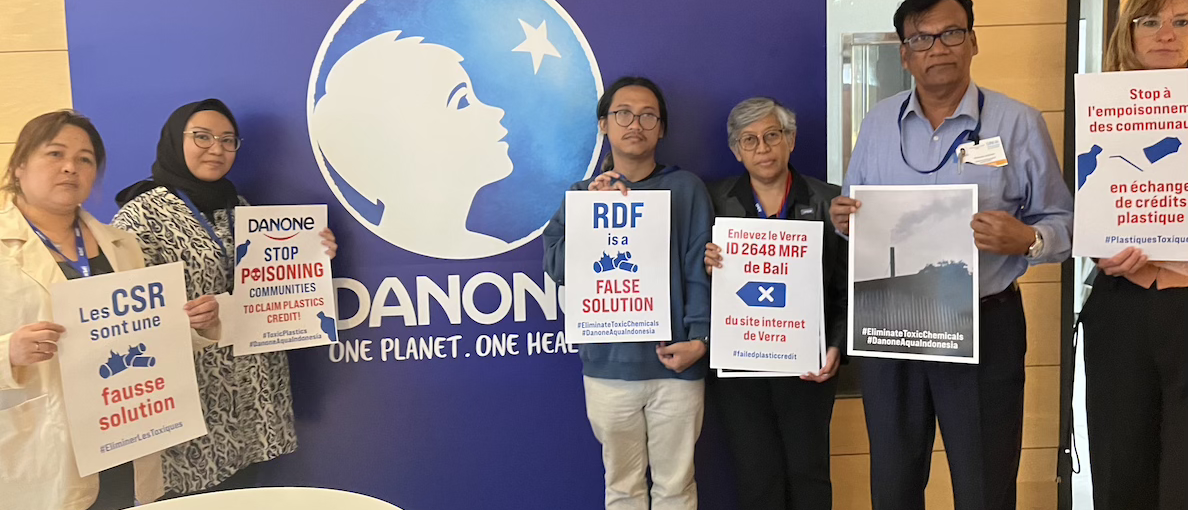 a group of IPEN and partner groups shows "stop plastic poisoning" posters at Danone headquarters