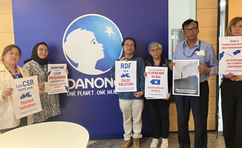 a group of IPEN and partner groups shows "stop plastic poisoning" posters at Danone headquarters