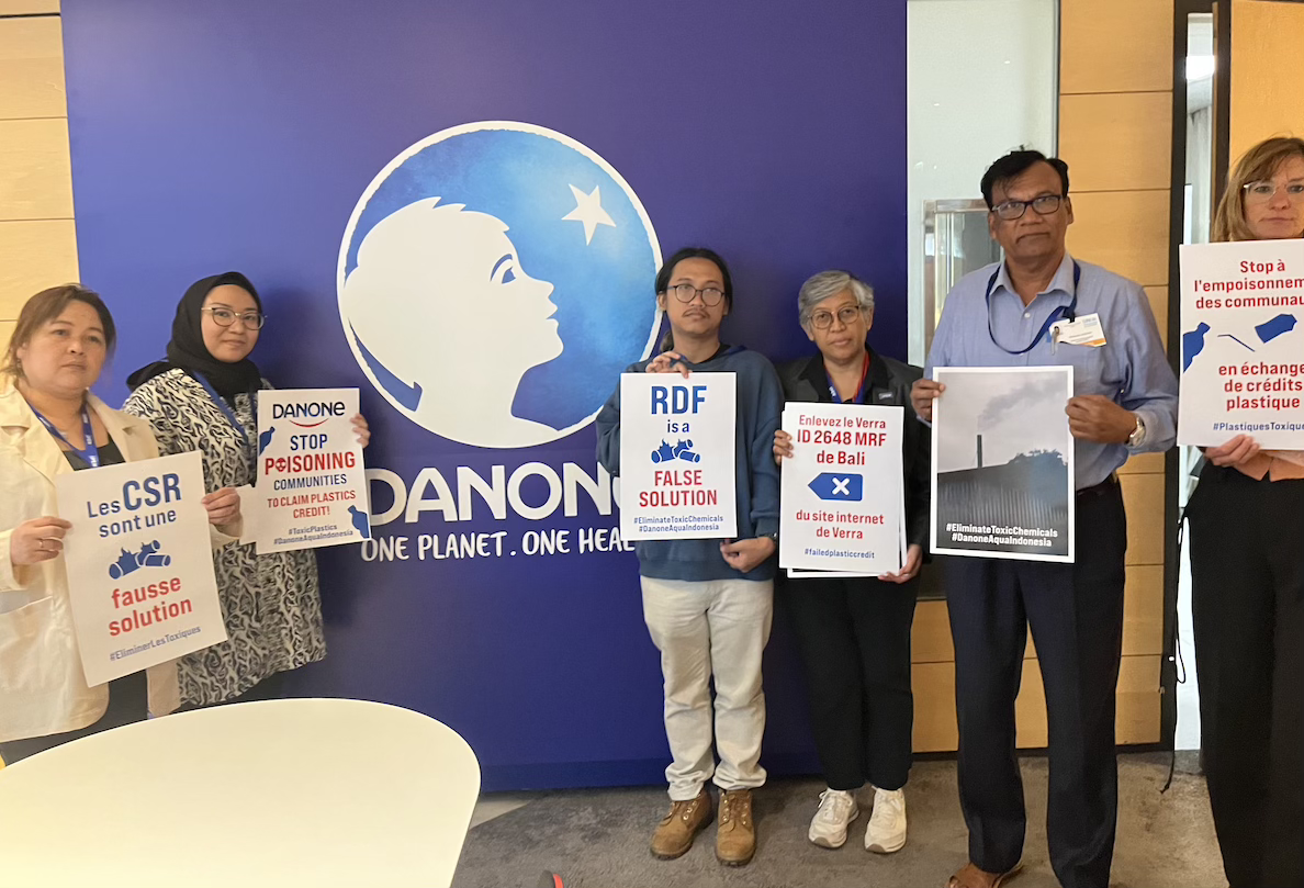 a group of IPEN and partner groups shows "stop plastic poisoning" posters at Danone headquarters